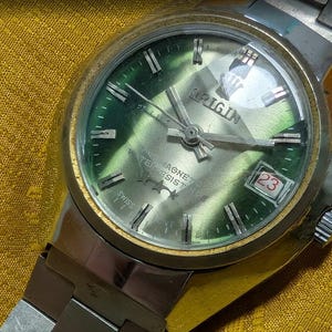 Vintage Origin Deluxe schweizisk klocka grön urtavla 1970-tals mekanisk armbandsur antimagnetiskt datum rostfritt stål för reparation