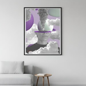 May include: A framed art print featuring a surreal collage. The artwork depicts a grayscale portrait with a cut-out head, from which smoke and clouds emerge. Purple and green orbs and clouds fill the background, creating a dreamlike atmosphere.