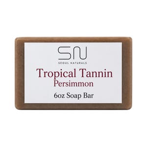 Op de afbeelding: Een rechthoekig 170g zeepblok met een bruine kleur en een wit label in het midden. Het label bevat het zwarte logo SN Seoul Naturals, gevolgd door de donkerrode tekst Tropical Tannin Persimmon en de zwarte tekst 6oz Soap Bar onderaan.