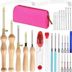 Könnte beinhalten: Eine Sammlung von Punch-Needle-Werkzeugen und Zubehör. Enthält Nadeln mit Holzgriffen, eine pinkfarbene Reißverschlusstasche, Nadeleinfädler und ein kleines rot-weißes Werkzeug. Verschiedene Nadelgrößen sind enthalten.