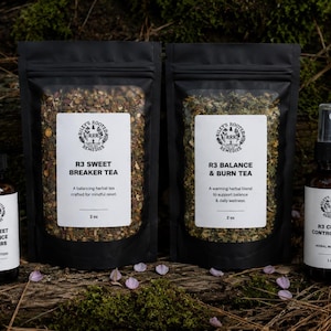 May include: An assortment of herbal remedies, including two black pouches of tea and two brown glass bottles. The bottles are labeled "R3 Sweet Balance Bitters" and "R3 Crave Control Mist". The tea pouches are labeled "R3 Sweet Breaker Tea" and "R3 Balance & Burn Tea".