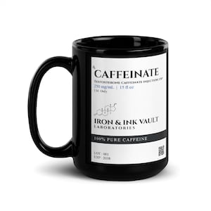 May include: A black ceramic mug featuring a white rectangular label with black text that reads CAFFEINATE, TESTOSTERONE CAFFEINATE INJECTION, USP, 250 mg/mL, 15 fl oz, I.M. ONLY, IRON & INK VAULT LABORATORIES, 100% PURE CAFFEINE, LOT: 001, EXP: 2038.