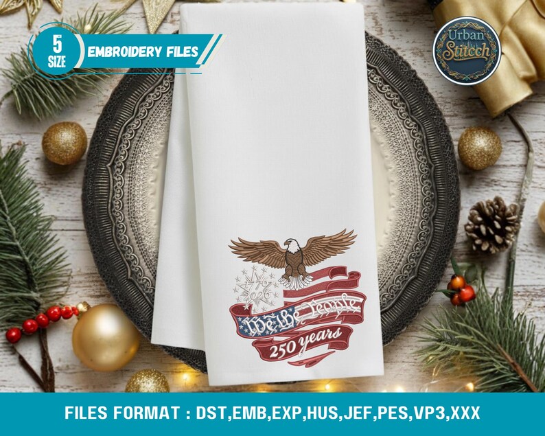 K&ouml;nnte beinhalten: Wei&szlig;es, besticktes Handtuch mit einem Adler, der amerikanischen Flagge und dem Text "We the People 250 years". Das Handtuch liegt auf einem dekorativen Teller mit Weihnachtsdekoration. Der Text "Embroidery Files" ist ebenfalls zu sehen.