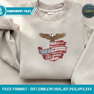 K&ouml;nnte beinhalten: Beiges Sweatshirt mit einem gestickten Design mit einem Adler, der amerikanischen Flagge und dem Text "We the People 250 years". Das Sweatshirt hat einen Rundhalsausschnitt und lange &Auml;rmel. Das Bild enth&auml;lt auch den Text "Embroidery Files".