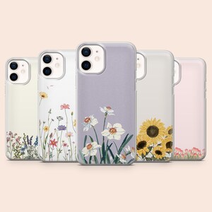 Op de afbeelding: Vijf doorzichtige smartphonehoesjes op een rij, elk met verschillende bloemmotieven. De ontwerpen bevatten kleine wilde bloemen, kleurrijke veldbloemen, witte narcissen op een lavendelkleurige achtergrond, grote gele zonnebloemen en roze tulpen.