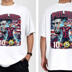 Puede incluir: Camiseta blanca con un gr&aacute;fico de un jugador de f&uacute;tbol, el nombre "Pulisic" arriba y la bandera de EE. UU. El dise&ntilde;o incluye el n&uacute;mero 10 y las palabras "USA", "Elite Winger" y "Captain America."