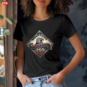 Pode incluir: T-shirt preto com um design gr&aacute;fico em forma de diamante com uma &aacute;guia, o texto "1776-2026" e "Freedom 250 Years". O design usa cores vermelho, branco, azul e dourado. Gola redonda.