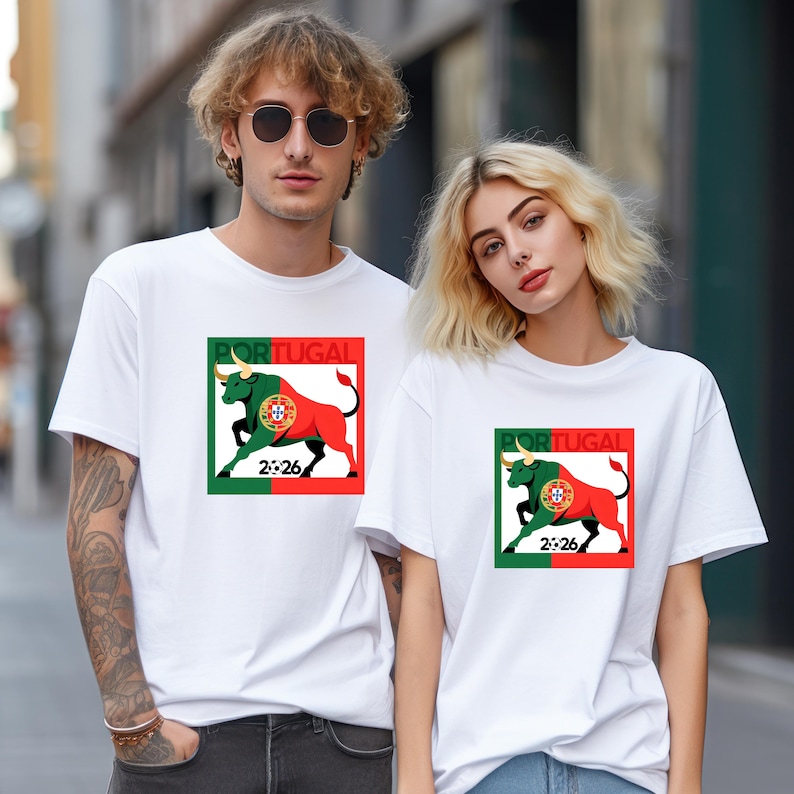 Pu&ograve; includere: T-shirt bianche con grafica di un toro. Il design include la parola "PORTOGALLO" e l'anno "2026" in verde, rosso e bianco. Il toro &egrave; rosso e verde, con un emblema della bandiera portoghese.