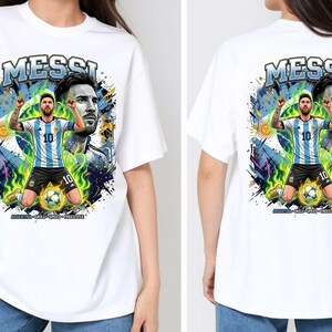 Puede incluir: Camiseta blanca con un gr&aacute;fico de un jugador de f&uacute;tbol con una camiseta a rayas azules y blancas, con la palabra "MESSI" encima. El dise&ntilde;o incluye un retrato del jugador y el texto "ARGENTINA - GOLD - PRIDE - PASSION".