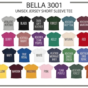 May include: A display of Bella 3001 unisex short sleeve tees in various colors. Colors include black, red, navy, and yellow. Each shirt has a color name printed on it in a contrasting color. The image is well-lit and shows the shirts in a grid.