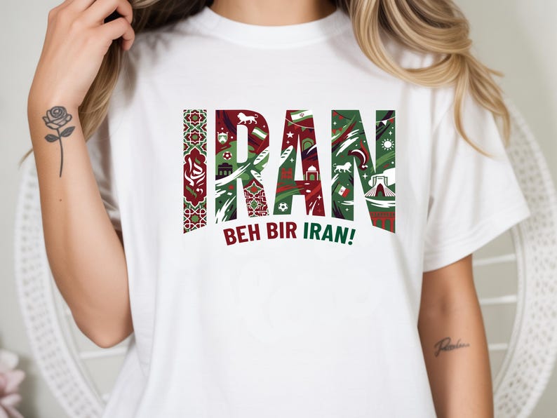 May include: White t-shirt with the word "IRAN" in a green and red design, featuring cultural symbols. The phrase "BEH BIR IRAN!" is printed below the word "IRAN".