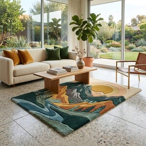 May include: A colorful area rug with a mountain and sun design. The rug features shades of green, blue, orange, and yellow. The rug is placed in a living room with a cream-colored sofa, wooden coffee table, and large windows.