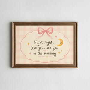 May include: A framed wall art print featuring a light pink gingham background and a central scalloped label. The text reads Night night, Love you, see you in the morning. It is decorated with a pink bow, a yellow crescent moon, and small stars.