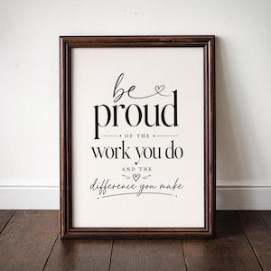 May include: A framed print with the words "be proud of the work you do and the difference you make" in black script and serif fonts. The frame is a dark brown color, and the background is white.