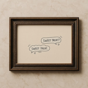 May include: A framed print with a light beige background. Two speech bubbles with the text "SWEET TREAT?" and "SWEET TREAT." are displayed in black. Small hearts and lines are drawn next to the text. The frame is dark brown.