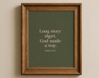 May include: A framed print with the text "Long story short, God made a way. Psalm 16:11" in a light beige font. The background is a muted green color, and the frame is a dark brown wood.