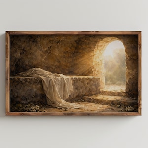 May include: A framed print shows an empty tomb with a stone bed and draped cloth. Sunlight streams through an arched opening, illuminating the interior. The artwork is in warm, earthy tones, with a wooden frame.