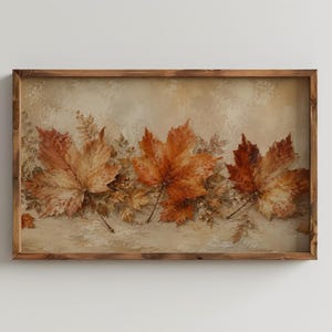 May include: A rectangular wall art piece featuring a horizontal arrangement of three prominent maple leaves in shades of orange, brown, and gold, set against a textured beige background, all enclosed within a dark brown wooden frame.