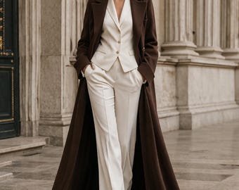 Elegante completo da donna a tre pezzi, composto da cappotto lungo marrone, gilet color crema e pantaloni a gamba larga. Abbigliamento formale, completo di lusso minimalista, abito da sposa.