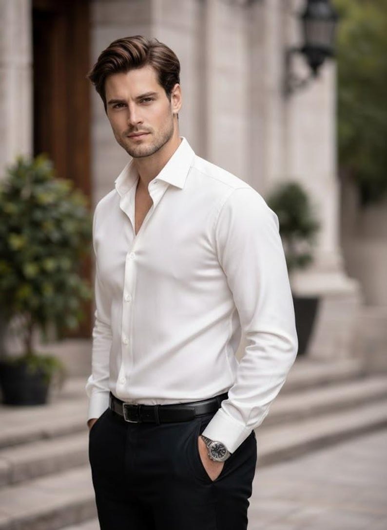 Puede incluir: Un hombre con una camisa blanca abotonada, pantalones negros y un cintur&oacute;n negro. Tambi&eacute;n lleva un reloj. La camisa est&aacute; desabrochada en la parte superior. El fondo es un edificio con columnas.