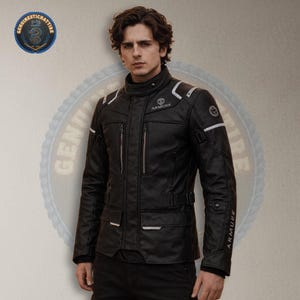 Puede incluir: Chaqueta de moto negra con detalles blancos y el logo "ARMURE". La chaqueta tiene múltiples bolsillos, un cuello alto y cierre de cremallera. La imagen también incluye un logo que dice "GENUINE STICHATTIRE".