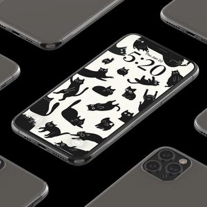 May include: A collection of dark gray smartphones arranged on a black surface. One phone displays a cat-themed wallpaper with black cat illustrations on a cream background. The time 5:20 is visible on the screen.