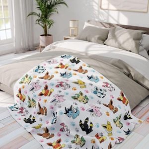 May include: White blanket featuring a repeating pattern of colorful cartoon characters and paw prints. The characters are in various poses and colors, including brown, yellow, pink, and blue. The blanket is draped over a bed with neutral-toned bedding.