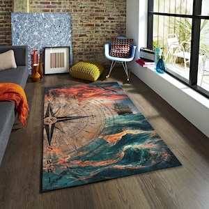 Pode incluir: Um tapete retangular com um tema náutico, retratando uma bússola e um navio no mar sob um pôr do sol. O design do tapete incorpora tons de azul, laranja e castanho, dando-lhe uma aparência vintage.