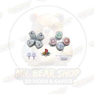 May include: A set of replacement controller buttons including a translucent directional pad with black arrows, four action buttons with colored triangle, square, circle, and cross symbols, two small white pegs, a logo button, and a rectangular bar.