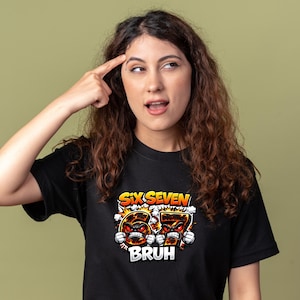 May include: Black t-shirt with the text "SIX SEVEN BRUH" in orange and white. The graphic features cartoon-style numbers with angry faces. The person in the image is pointing to their head.