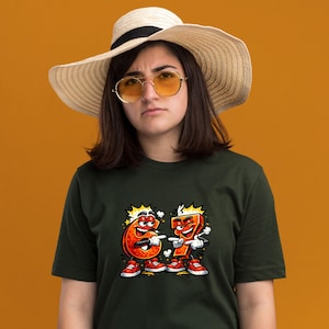 May include: Dark green t-shirt featuring a cartoon graphic of the numbers six and seven, each with a face, arms, legs, and red sneakers. The numbers are pointing at each other. The person in the image is wearing a straw hat and sunglasses.