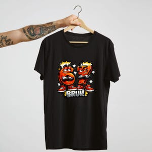 May include: Black t-shirt featuring a cartoon graphic of the numbers 6 and 7 with arms, legs, and red sneakers. The word "BRUH!" is printed below the numbers in a white, bold font.