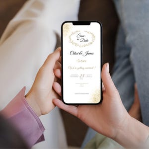 May include: A smartphone screen showing a digital wedding invitation. The invitation has gold text and floral details on a white background. The text says "Save the Date," "Chloe & James," and "We're getting married!" The date is May 23, 2024.
