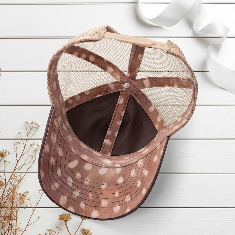 Light pink women’s Christian trucker hat with white embroidered “Jesus Saves” text, two toned hat. Styled on a smiling woman with curly ponytail in front of a modern church. Vintage washed unstructured ponytail baseball cap with feminine floral details and faith-inspired boutique style.