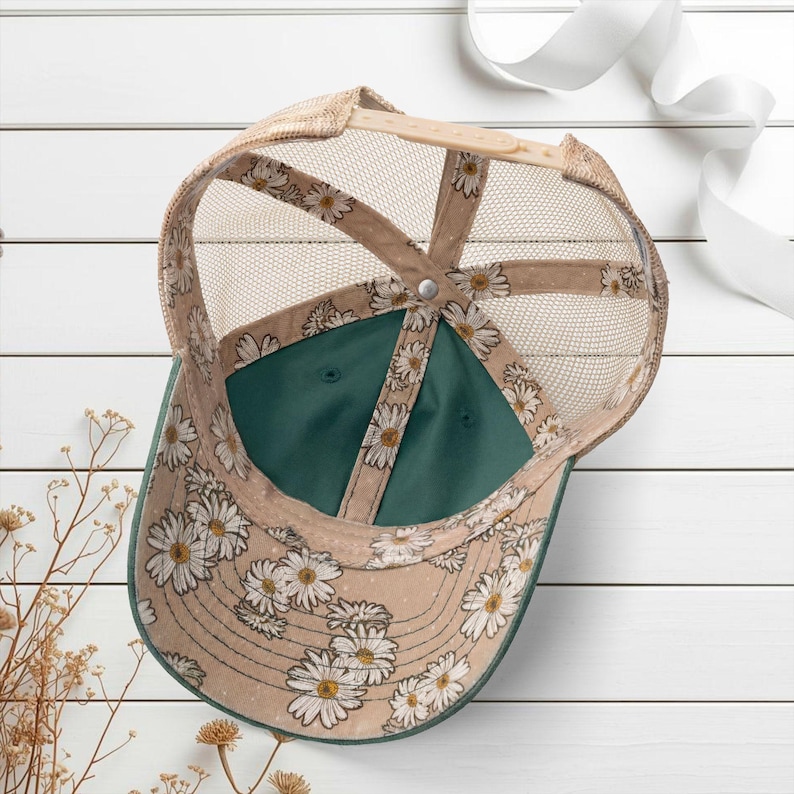 Light pink women’s Christian trucker hat with white embroidered “Jesus Saves” text, two toned hat. Styled on a smiling woman with curly ponytail in front of a modern church. Vintage washed unstructured ponytail baseball cap with feminine floral details and faith-inspired boutique style.