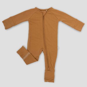 K&ouml;nnte beinhalten: Ein brauner Baby-Schlafanzug mit langen &Auml;rmeln und einem durchgehenden Rei&szlig;verschluss. Der Schlafanzug hat ein kleines gepunktetes Muster an den Kn&ouml;chelb&uuml;ndchen. Dieses bequeme Kleidungsst&uuml;ck ist f&uuml;r Babys konzipiert.