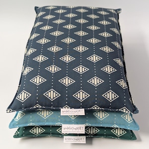 May include: Three stacked rectangular pillows in navy, teal, and green. Each pillow features a repeating geometric diamond pattern in a lighter color. The pillows have a soft, cushioned appearance. The text "madeforyoubyKT.etsy.com" is visible on each pillow.
