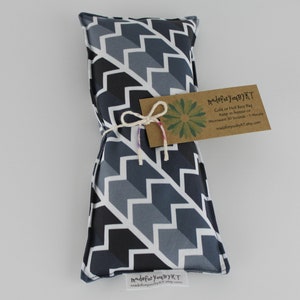 May include: A gray and black chevron patterned fabric hot or cold rice bag tied with twine. The bag has a brown tag that reads "MadeForYouByKT" and includes instructions for use: "Cold or Hot Rice Bag. Keep in freezer or microwave 30 seconds - 1 minute. MadeForYouByKT.etsy.com"