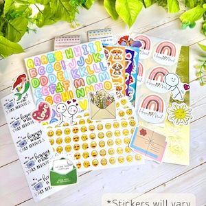 May include: A collection of assorted decorative stickers featuring colorful alphabet letters, emojis, rainbows with the text Happy Mail, cartoon dogs, stick figures, floral envelopes, and suns. A rectangular note states Stickers will vary based on theme.
