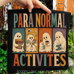 May include: A black t-shirt featuring the text PARA NORMAL ACTIVITES in a retro font. Below the text are four panels showing cartoon ghosts: one holding notebooks, one with sticky notes, one with a coffee cup, and one hugging a smaller ghost.