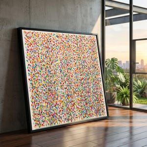 Può includere: Un dipinto su tela quadrato in una cornice nera caratterizzato da un motivo denso e strutturato di piccole macchie di vernice multicolore nelle tonalità del rosso, giallo, blu, verde, arancione e viola su sfondo bianco, esposto in una stanza.