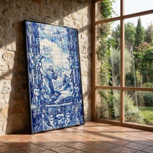 Peut inclure: Une œuvre d'art encadrée en carrelage bleu et blanc représentant une scène religieuse. L'œuvre présente des personnages, des anges et des éléments architecturaux. Les carreaux sont disposés en format rectangulaire, avec un cadre noir. L'œuvre est appuyée contre un mur en pierre.
