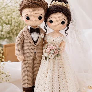 May include: Crocheted wedding dolls of a bride and groom. The groom wears a tan suit with a bow tie. The bride has a white dress, veil, and holds a bouquet of pink and white flowers. The dolls are handmade with detailed stitching.