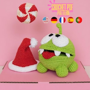 May include: A crocheted green monster with white eyes, teeth, and a red tongue, alongside a red Santa hat with a white pom-pom and a red and white striped ball. The image includes the text "CROCHET PDF PATTERN".