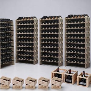 May include: Wooden wine racks filled with dark bottles. Several racks are arranged together, with smaller wooden crates holding additional bottles in front. The racks are made of light-colored wood, and the bottles are dark.