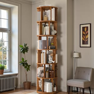 May include: A tall, wooden, rotating bookshelf filled with books and decorative items. The bookshelf has a circular design with multiple shelves. The wood has a warm, natural tone. The shelves are filled with books, sculptures, and other decor.