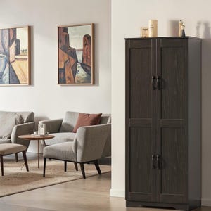 May include: A tall, dark brown wooden storage cabinet with two vertical doors, each featuring two rectangular panels and black metal handles. The cabinet has a wood grain texture and stands upright on a flat base, providing enclosed storage space.