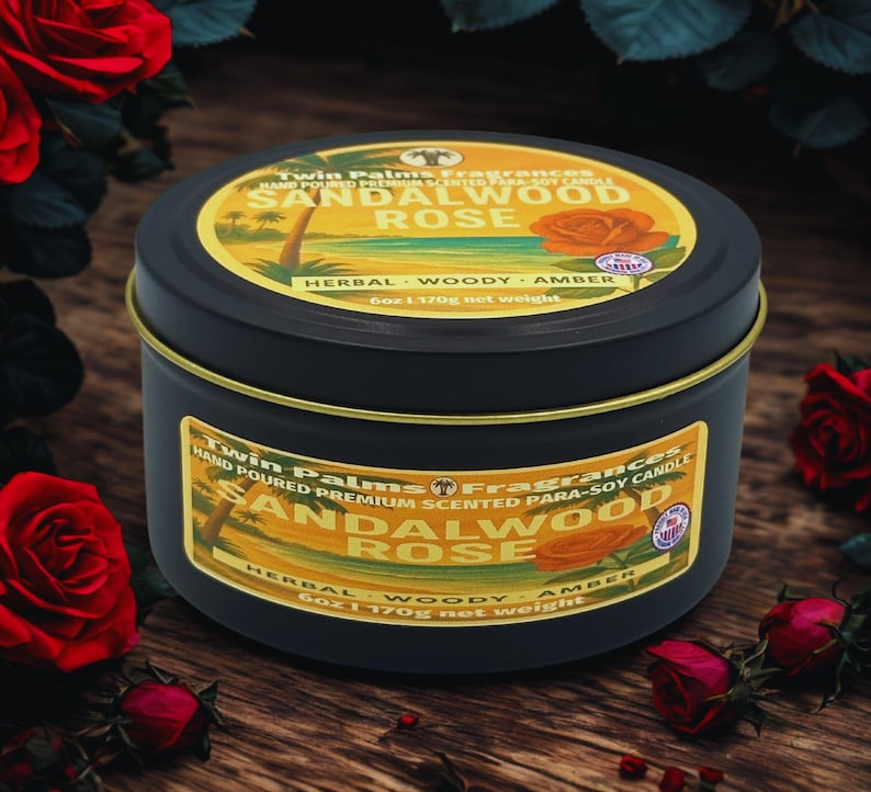 A black tin candle with a gold rim and label featuring the text "Sandalwood Rose". The label includes a graphic of a rose and palm trees. The candle is 6 oz (170g) and is surrounded by red roses.