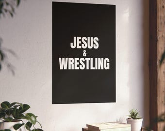 Puede incluir: Un póster de pared rectangular negro que presenta el texto blanco JESUS & WRESTLING centrado en una fuente sans-serif en negrita. El póster se muestra verticalmente en una pared lisa, proporcionando un visual de alto contraste.