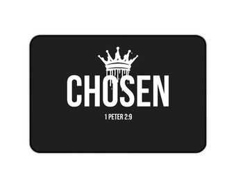 Puede incluir: Una alfombrilla rectangular negra con un gráfico blanco de una corona con efecto de goteo sobre la palabra CHOSEN en letras mayúsculas negritas. Debajo del texto, la referencia 1 PETER 2:9 está impresa en una fuente blanca más pequeña.